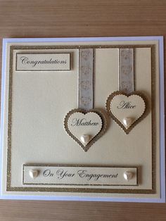 two heart shaped buttons are attached to the back of a card that says congratulations, mr and mrs engagement