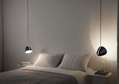 a bed with two lamps hanging from it's sides