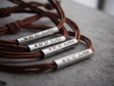 three personalized bracelets with writing on them