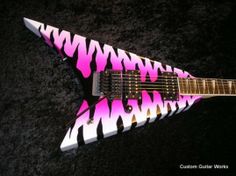 an electric guitar with pink and black designs on it