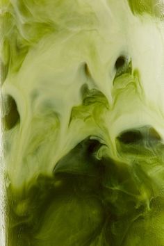 green liquid in a glass with white and black swirls on the bottom, as seen from above