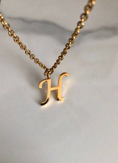 Letter H necklace, set on a stainless steel ,golden color chain. Chain length 19'  With addition cost there is an option to add a white freshwater pearl, as a charm, next to the letter. 6 mm, white round pearl Kindly choose your option. Beautiful spiritual gift. Please make sure you to pay attention to the size of the pendant. I have added pictures next to 25 cent coin, and measurement tape.  Need a different length just write it to me in the "message to the seller" box of the order form. **LIMI H Necklace Initial, H Letter Necklace, Gold Dainty Stainless Steel Name Necklace, Dainty Gold Stainless Steel Name Necklace, Hypoallergenic Gold Initial Necklace Gift, Gold Minimalist Initial Necklace In Stainless Steel, Minimalist Gold Stainless Steel Initial Necklace, Letter H Necklace, H Name