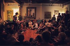 a group of people sitting around each other in front of a man on a stage