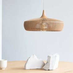 a wooden light hanging over a table next to two pieces of white rock on top of it