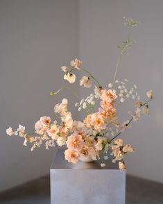 a vase filled with lots of flowers on top of a table