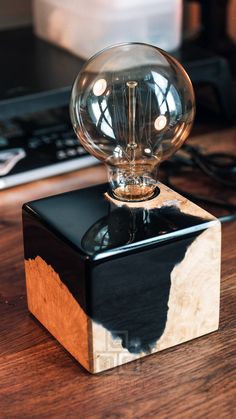 a light bulb sitting on top of a black and white box next to a keyboard