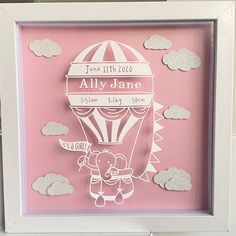 a pink and white frame with a drawing of a hot air balloon in the sky