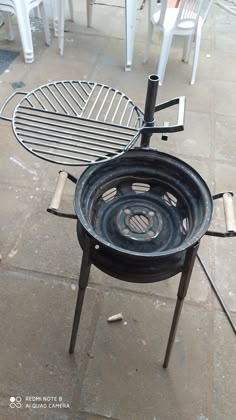 an outdoor bbq grill sitting on top of a tiled floor next to white chairs