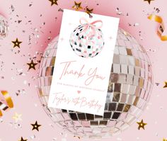 a thank card sitting on top of a disco ball with confetti around it