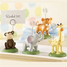 there are three little toy animals on the small stand with a name tag attached to them