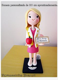 a small figurine holding an apple on top of a table