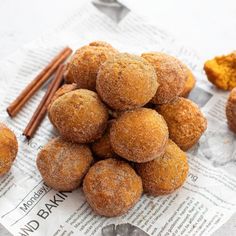 cinnamon sugar balls and cinnamon sticks on top of newspaper