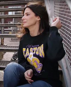 a woman is sitting on the bleachers