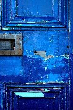 an old blue door with peeling paint on it