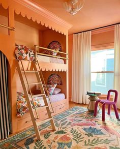 a bedroom with bunk beds and colorful furniture in the room, including a ladder that leads to another bed