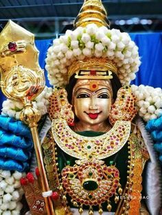 an idol is displayed in front of a blue backdrop with white balls and gold decorations