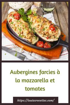 two stuffed eggplant halves with tomatoes and parsley on the side in a cast iron skillet