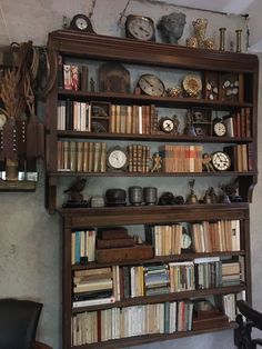 a bookshelf filled with lots of different types of clocks on top of it