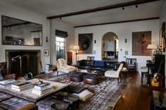 a living room filled with furniture and a fire place in the middle of an open floor plan