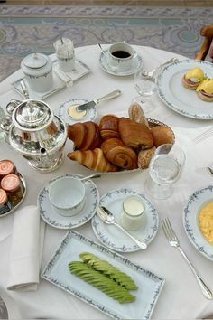 a white table topped with plates and cups filled with food