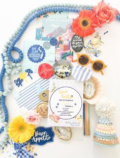 an assortment of items are displayed on a white surface with blue and yellow accessories around it