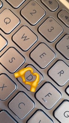 a computer keyboard with a small yellow object on it