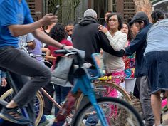 a group of people on bicycles in the street with one person holding another's hand