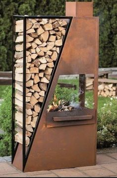 an outdoor fire place with logs stacked on it's sides and a metal chimney