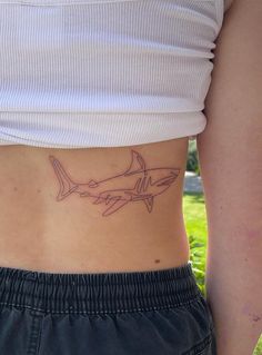 a woman's stomach with a shark tattoo on her lower body and the bottom part of her abdomen