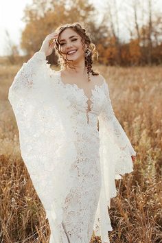 a woman in a white dress standing in a field