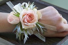 a close up of a person's wrist with flowers on it and ribbons around the wrist