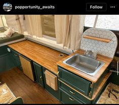 an rv kitchen with green cabinets and wood counter tops is pictured in this image from the inside