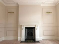 an empty room with a fireplace and white walls