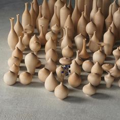 a group of vases sitting on top of a cement floor next to each other