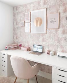 a white desk topped with a laptop computer sitting on top of a wooden chair next to a wall