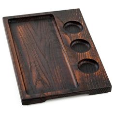 a wooden tray with three holes in it