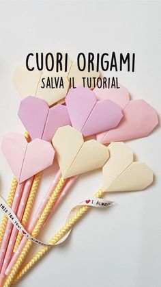 several heart shaped paper straws are arranged on a white surface with the words cuori origami above them