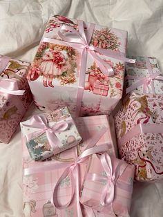 many wrapped presents are piled on top of each other with pink ribbons and bows around them