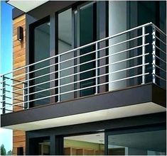 a balcony with railings and glass doors on the side of a modern home building