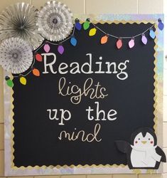 a sign that reads reading lights up the mind with some paper decorations on top of it