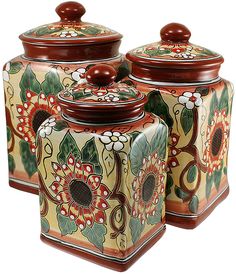 three ceramic canisters with floral designs on them