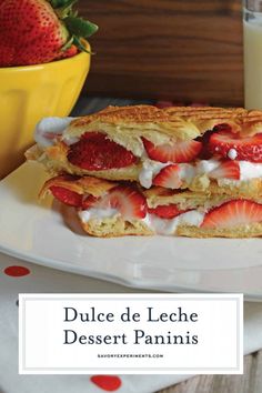 a close up of a sandwich on a plate near a glass of milk and strawberries