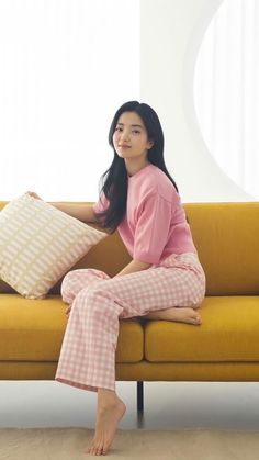 a woman sitting on a couch with pillows