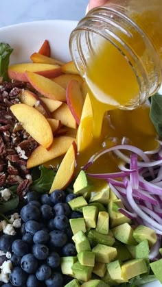 a white plate topped with fruit and vegetables next to a jar of juice on top of a table