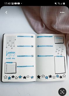 an open notebook with blue and white stars on it, next to a pink fabric