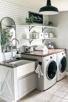 a washer and dryer in a room with white tiles on the walls,