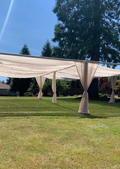 an outdoor wedding setup with white drapes and lights