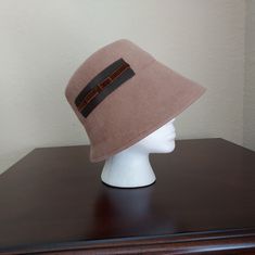 Tan Felted Wool Cloche Hat With Gross Grain And Velvet Ribbon Detail On Side. Never Worn. From Lola Hats Nyc Fall/Winter 2002 Brim (Front) 4in Brim (Back) 2.5in Crown Height 3in Ribbon Detail 5in X 1.5in Winter Beige Flat Brim Hat Band, Beige Felt Hat With Short Brim For Winter, Beige Short Brim Felt Hat For Winter, Beige Brimmed Felt Hat For Winter, Fitted Beige Cloche Hat, Cream Short Brim Felt Hat For Winter, Cream Felt Hat With Short Brim For Winter, Classic Beige Cloche Hat With Flat Brim, Adjustable Beige Cloche Hat For Fall