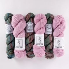 four skeins of yarn in pink, green and brown colors on a white background