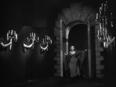 an old photo of a woman standing in front of chandeliers